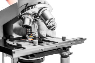 Scientist hands with microscope close-up shot in the laboratory